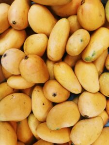 A vibrant pile of fresh yellow mangoes, highlighting the tropical fruit's natural beauty and summer appeal.